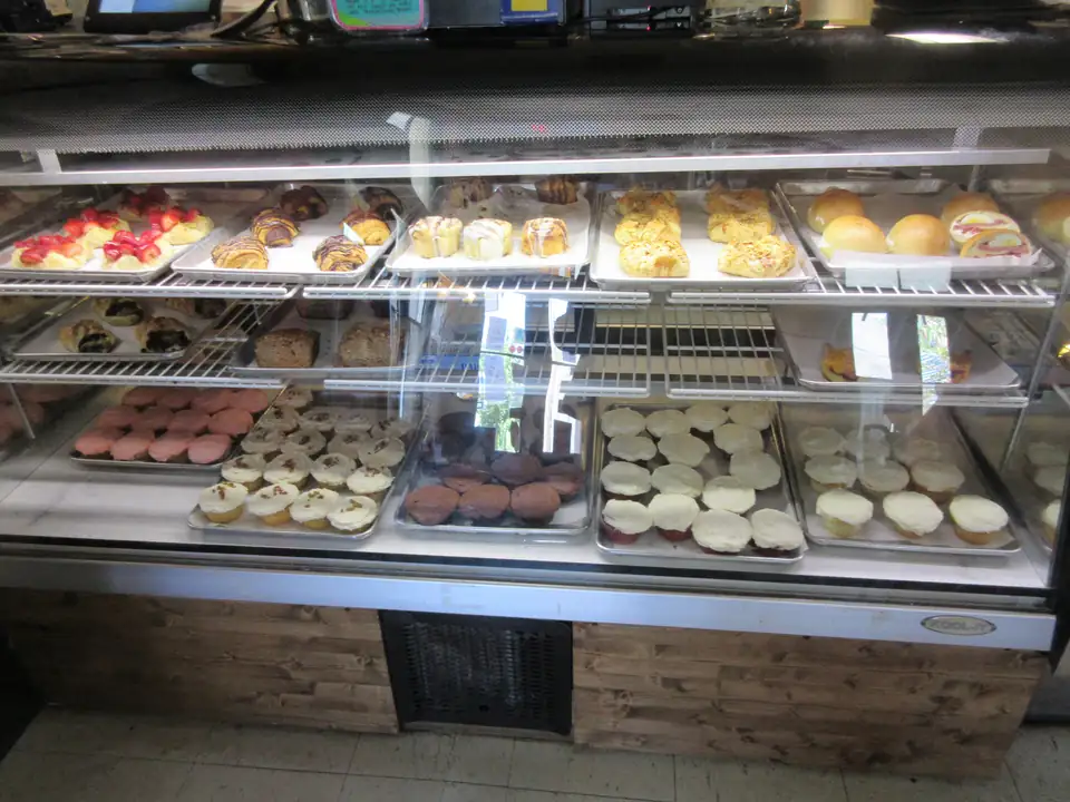 A full bakery case of pastries, danishes, cupcakes and iced cookies.