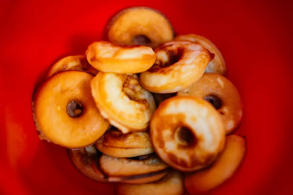 A bowl of small golden cake doughnuts.