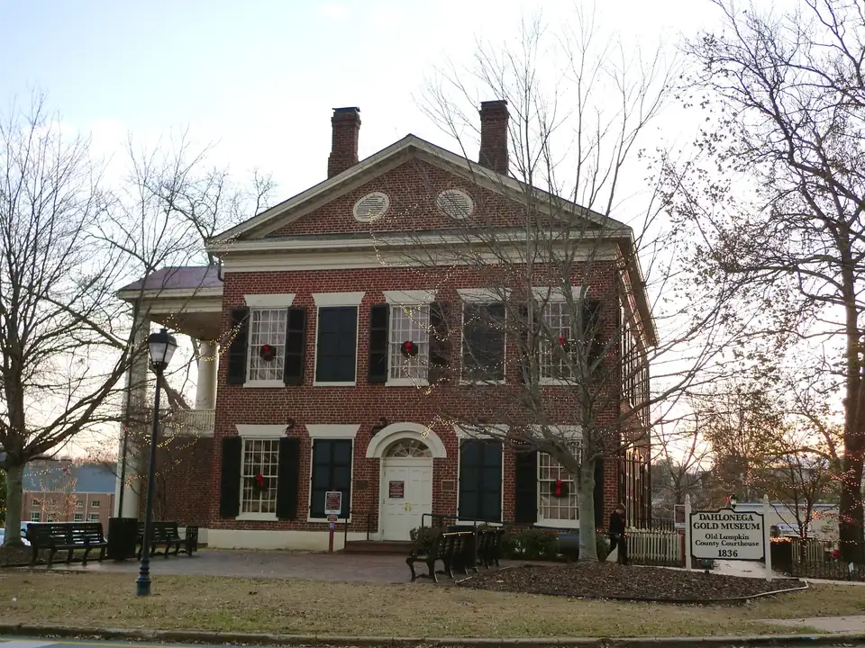 Holiday string lights and wreaths on the old brick courthouse that anchors Dahlonega's square, late on a November afternoon.