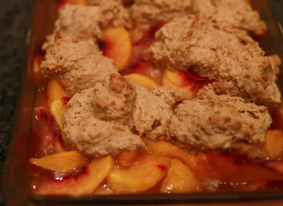 Homemade peach cobbler with a biscuit topping, fresh from the oven.